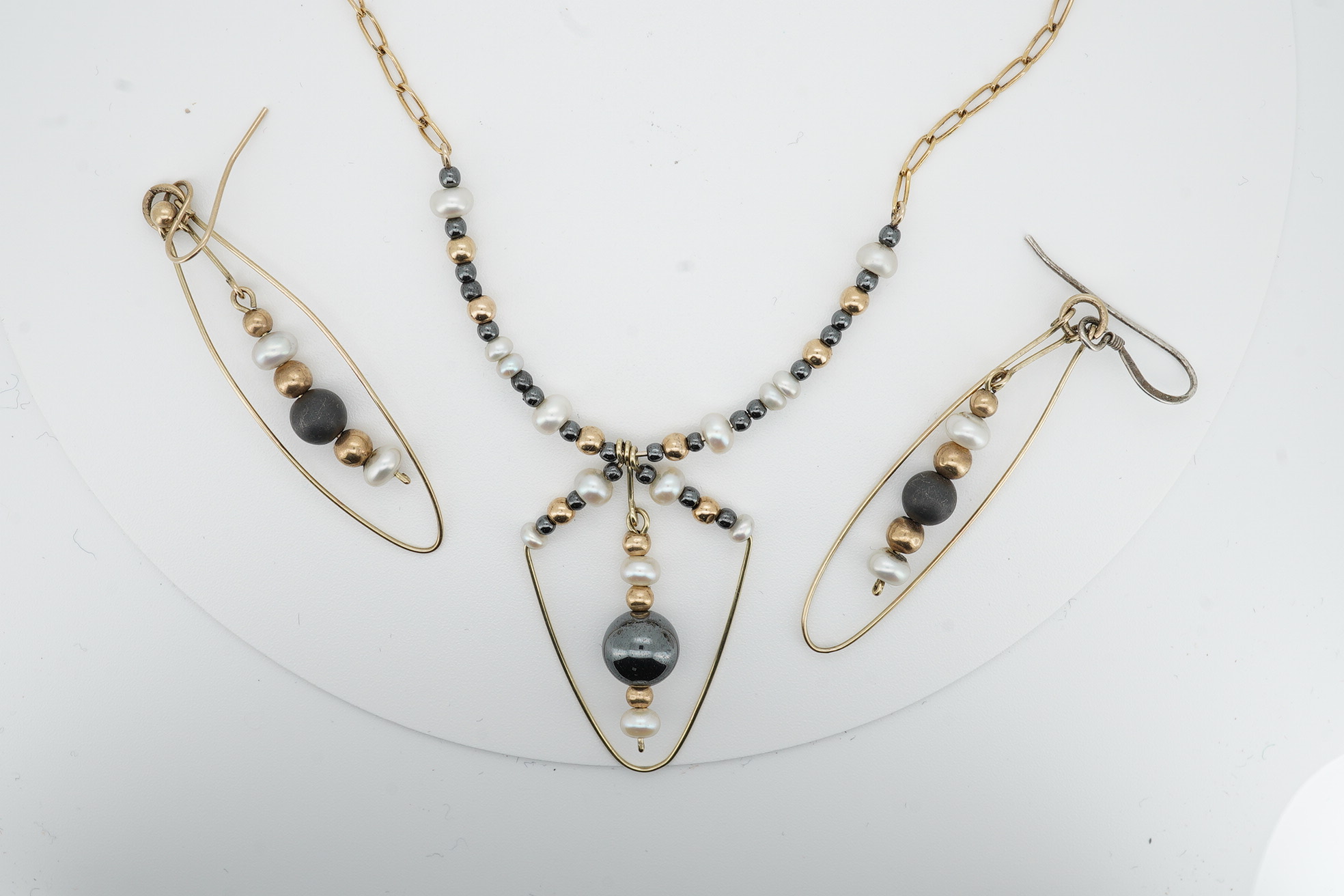 A modern Uno-A-Erre 9ct gold seed pearl and hematite cluster set necklace, approx. 40cm, with a pair of similar drop earrings, gross weight 10 grams. Condition - fair